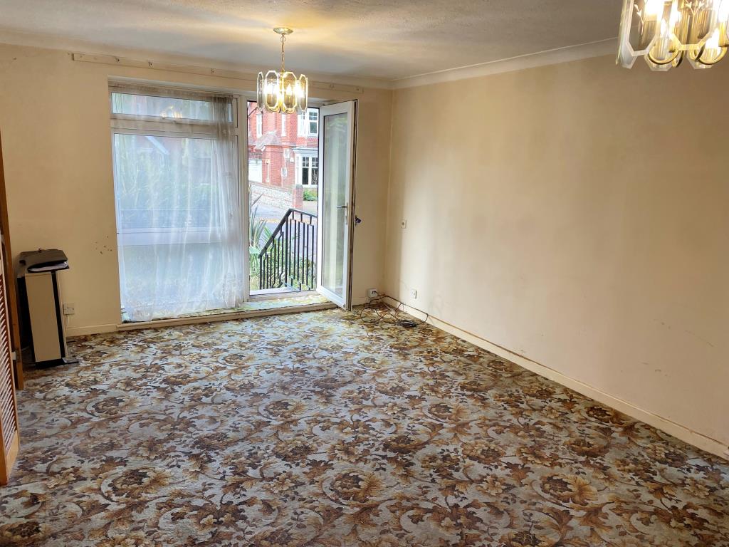 Lot: 32 - FLAT WITH GARAGE AND GARDEN IN NEED OF UPDATING - Living room with door to rear garden